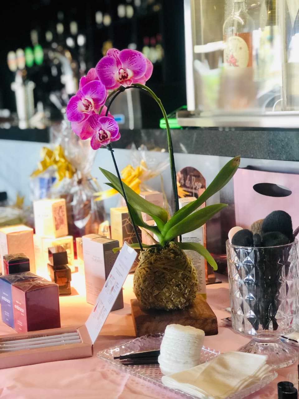 Orquídea em kokedama sobre base de madeira