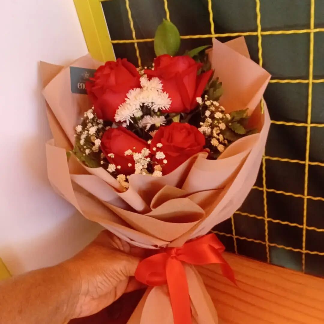 Buquê de quatro rosas vermelhas com papel kraft